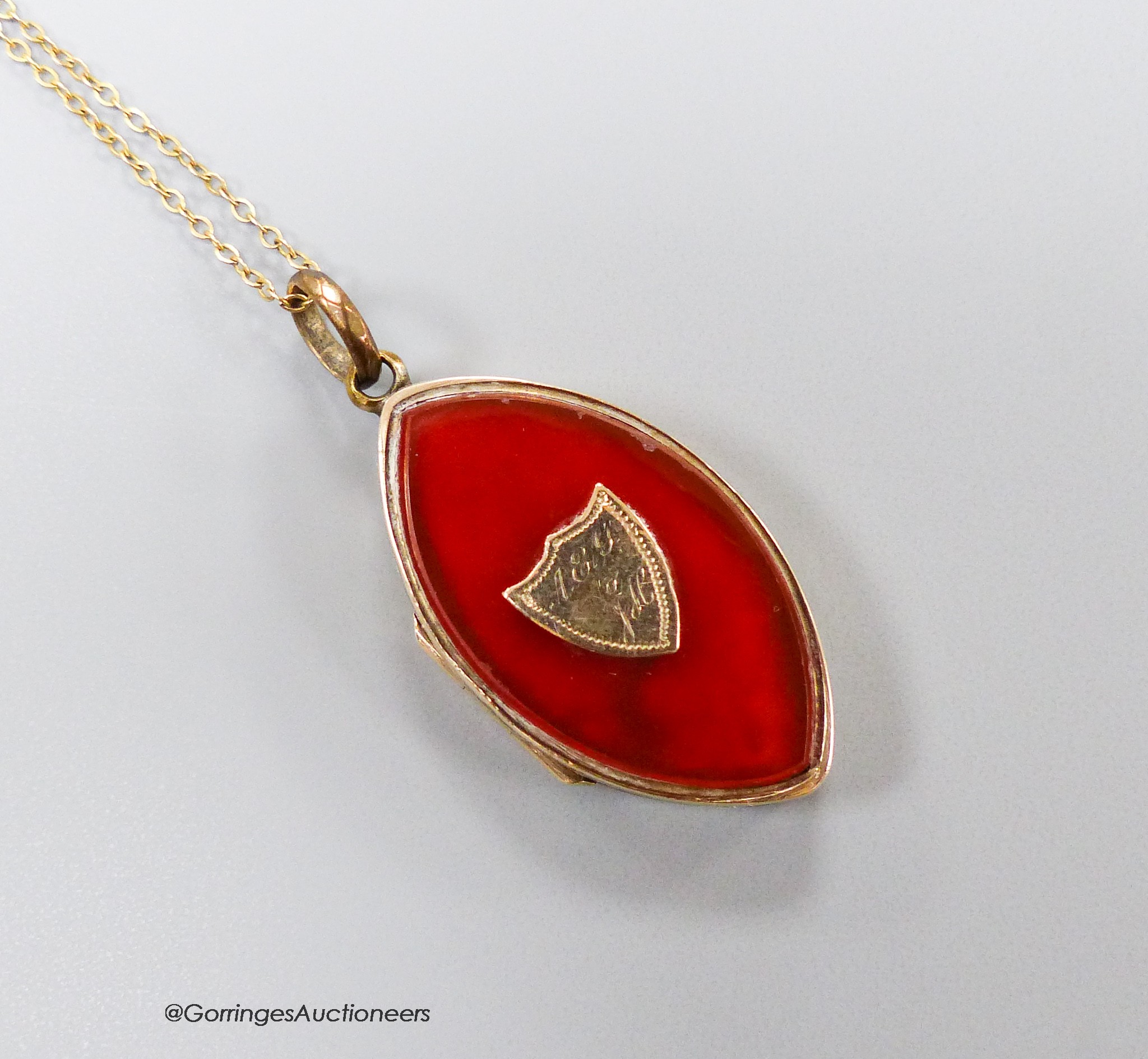 A 19th century engraved yellow metal and carnelian set navette shaped locket pendant, 31mm, on a later 9ct finelink chain, gross 9.1 grams.